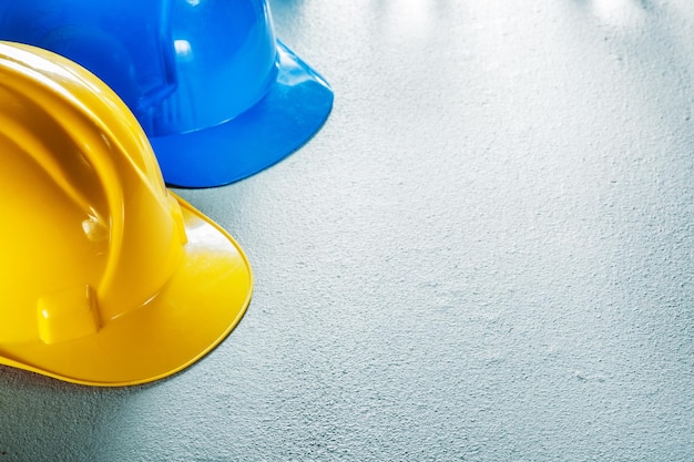 Protective hard hats on concrete background.