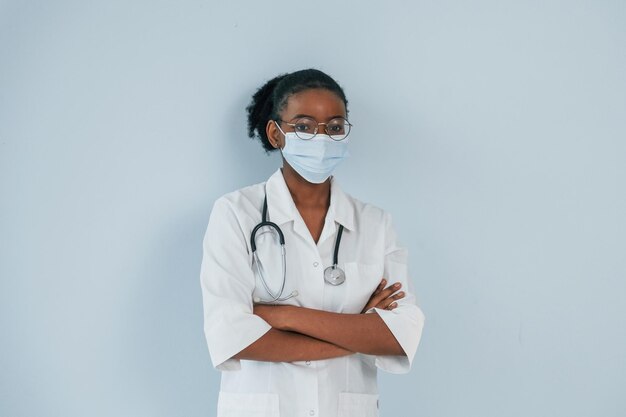 In protective mask young african american woman is against\
white background