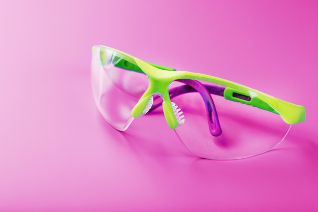 Protective open glasses isolated on a pink background.