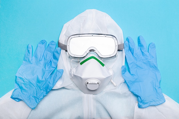 Photo protective suit to fight to coronavirus covid-19 virus outbreak. safety wear isolated on blue background