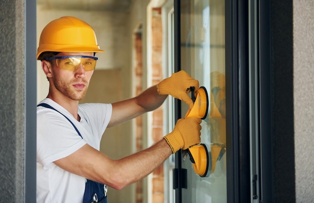 In protective wear Young man working in uniform at construction at daytime