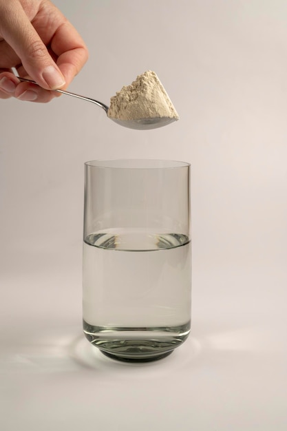 Protein powder and a spoon with glass of water Food supplements