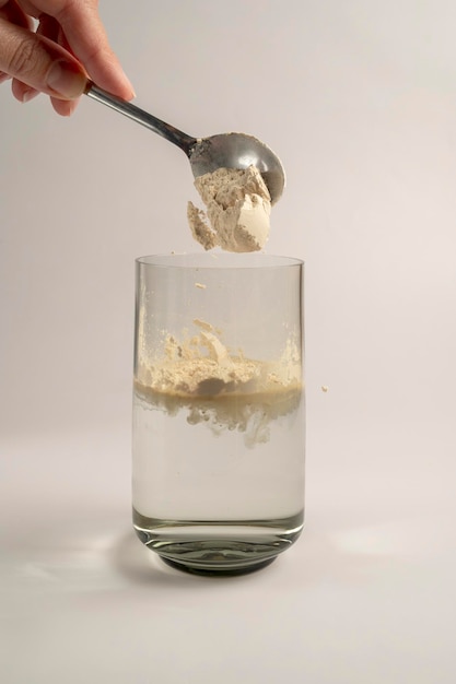 Protein powder and a spoon with glass of water Food supplements