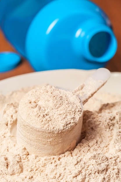 Photo protein powder with plastic scoop and blue shaker