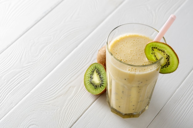 Protein shake with kiwi on white wooden boards. Fresh milkshake with kiwi. Smoothies.