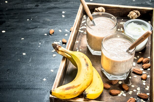 Protein smoothie with banana and nuts on black background