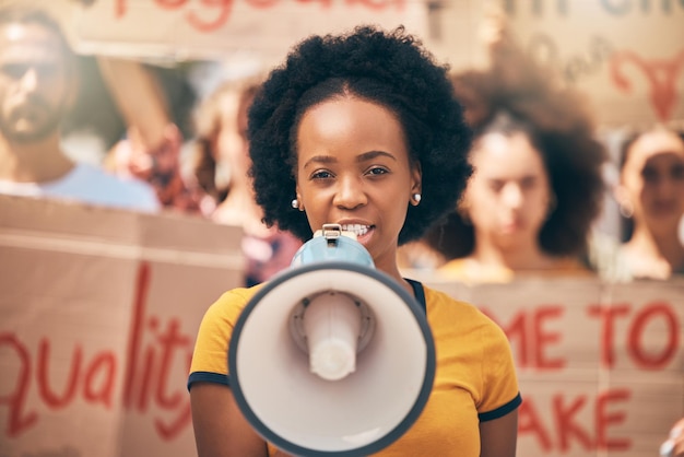 Protest loud speaker and rally with a woman activist speaking during a march for equality in the city Freedom speech and community with a young female protestor in fight for human rights