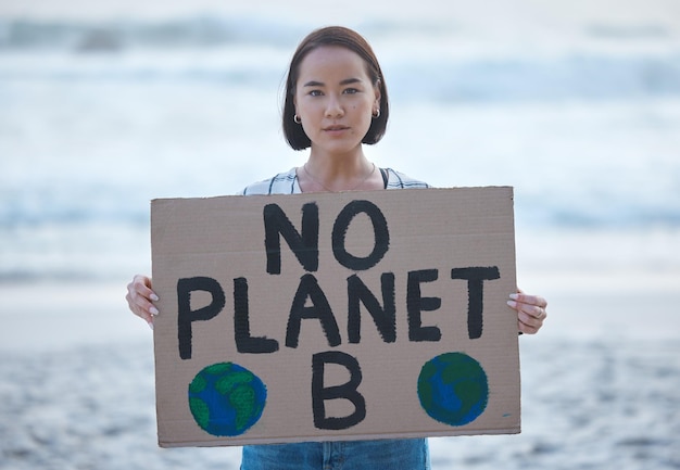 사진 해변에서 오염과 지구 온난화를 막기 위해 기후 변화에 대한 신호를 보내는 행성 지구와 여성에 항의하다