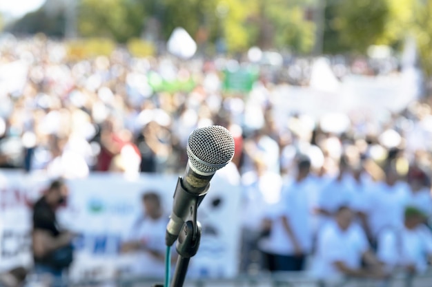 Protest or public demonstration focus on microphone blurred crowd of people in the background