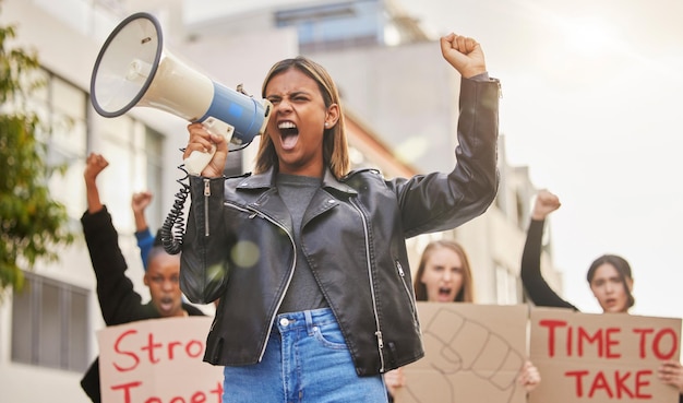 Фото Протестные крики и женщина с мегафоном в городе маршируют за гендерное равенство, справедливость и свободу демонстрация социальных изменений и толпа людей за права человека свобода слова и революция