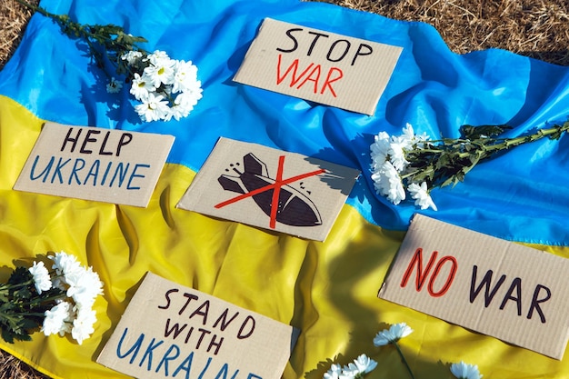 Foto protestbord liggend op oekraïense vlag stand met oekraïne concept