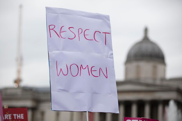 A protestor holds a political banner with respect women message
