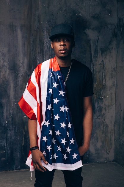 Гордый афро-американский мужчина с американским флагом на темном фоне