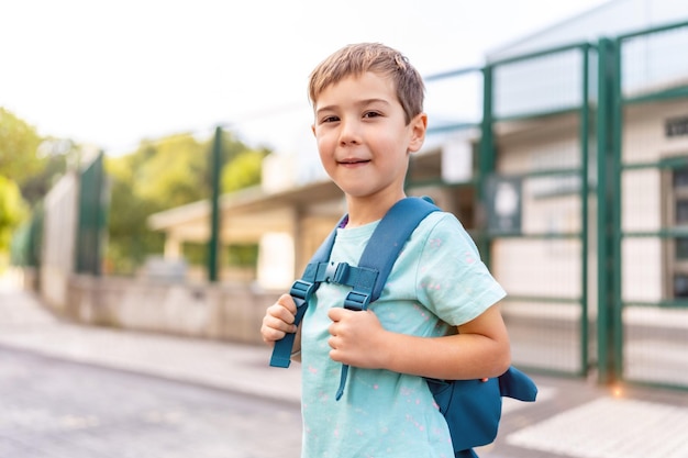 proud boy next to school at first day of school