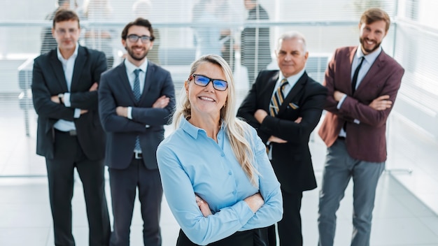 Proud business woman standing in front of a business team. success concept