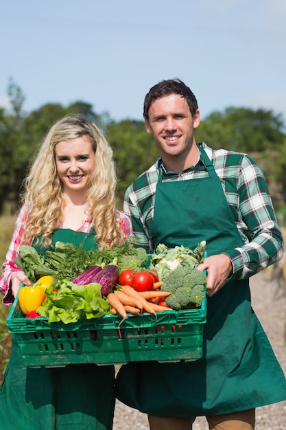 バスケットに野菜を見せる誇らしげな夫婦