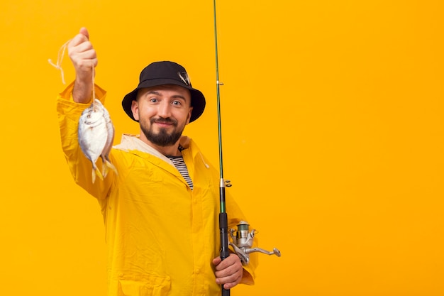 Proud fisherman holding catch and fishing rod