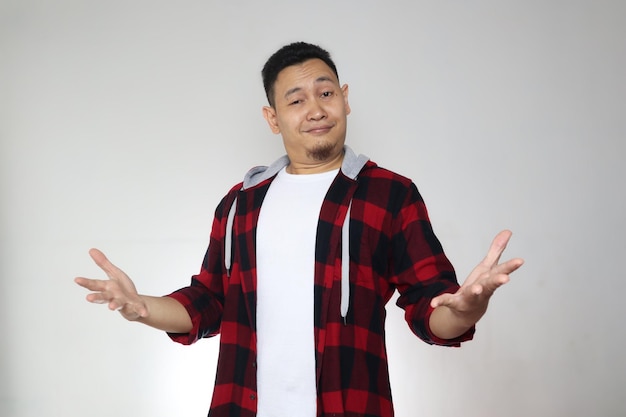 Proud funny Asian man open his arms wide shows his self pride confidence over grey