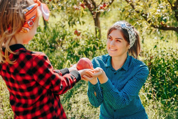 A proud mother and her daughter sharing a special moment while picking apples together in their fami