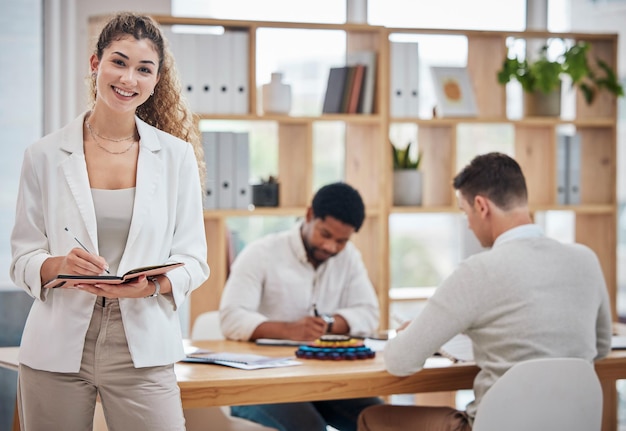 Proud portrait and professional taking notes in the office Assertive friendly and working lady in corporate company Writing feedback and team manager or strategy at business meeting with ceo