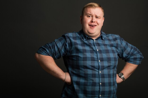 Proud young man on black wall