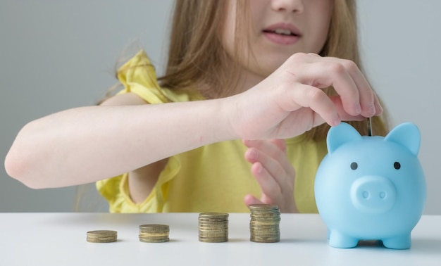 Provident economical kid girl put money into piggy bank saving for future needs