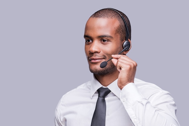 Providing best support. Confident young African man adjusting his headset and looking away