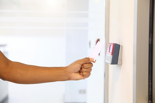 Proximity card reader door unlock Hand security man using ID card on fingerprint scanning access control system for identity verification to open the door or for security safety or check attendance