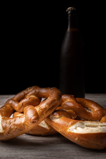 prtzels en bierfles voor oktoberfest-achtergrond in donkere stijl