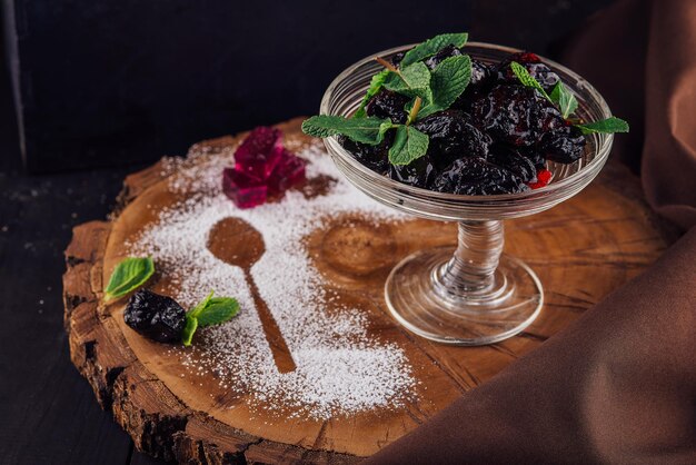 Prunes in a glass bowl on a rustic wooden