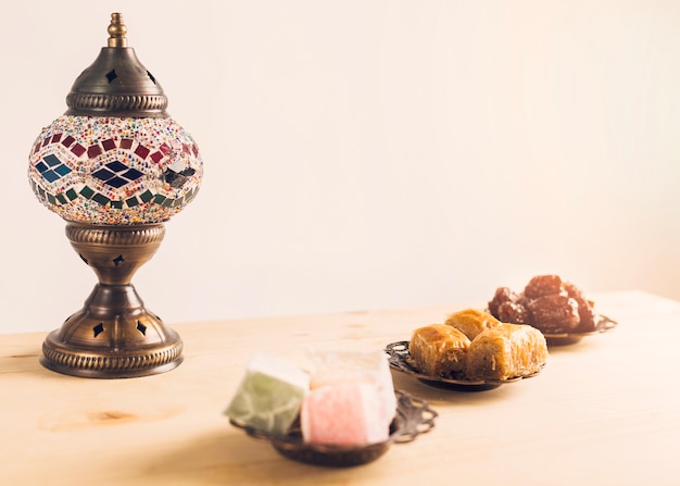 Prunes near baklava and Turkish delights on saucers