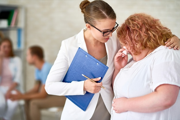 Psichiatra che conforta piangendo giovane donna