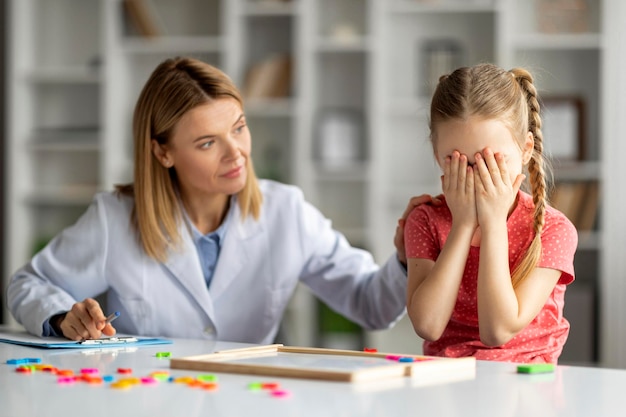 Psychische problemen bij kinderen maken een klein meisje van streek tijdens een therapiesessie met een psycholoog