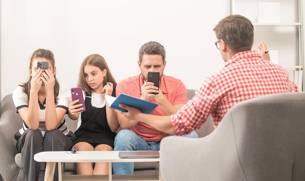 Foto lo psicologo fornisce una terapia familiare per la dipendenza da mamma e figlia di papà e figlia dipendenti dal telefono