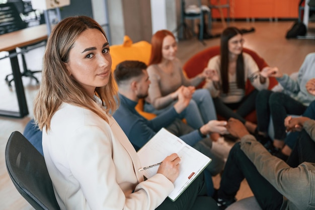 Foto lo psicologo è con il taccuino un gruppo di persone sta facendo una riunione di terapia insieme