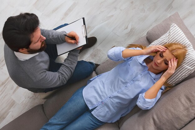 Photo psychologist listening to desperate patient and writing down notes mental health and counseling top