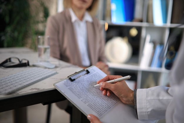 Psychologist listening to her patient and writing down notes.\
mental health and counseling concept.