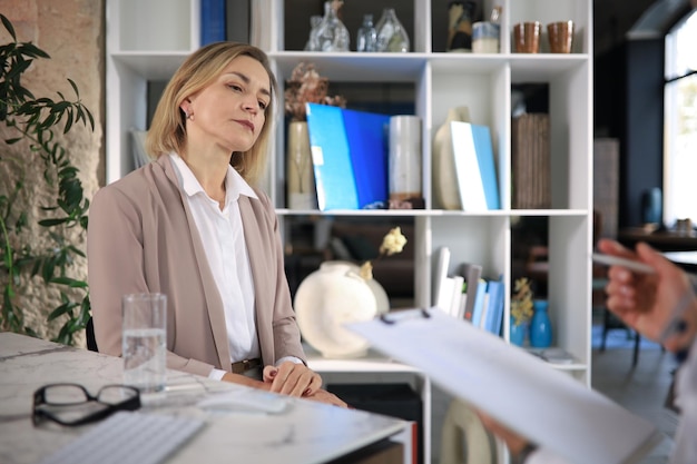 Psychologist listening to her patient and writing down notes Mental health and counseling concept