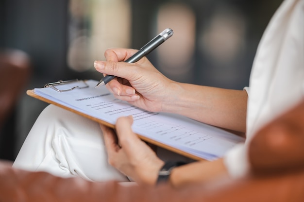 Psychologist making notes in medical history while understanding problems of a woman patient