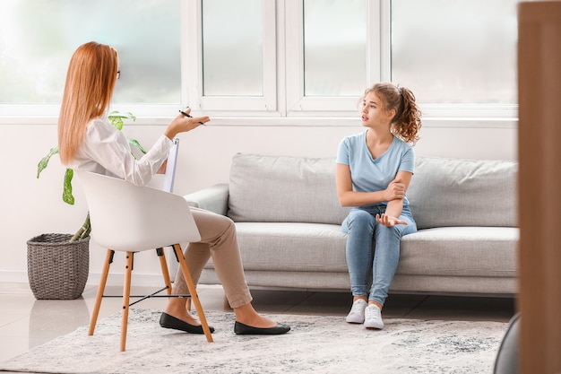 psychologist working with teenage girl in office