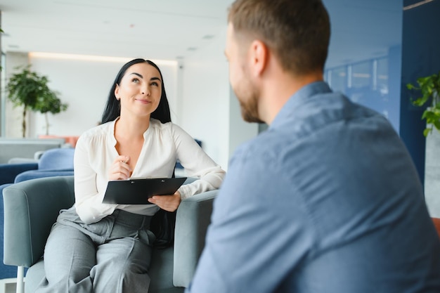 Psicologia terapia mentale e concetto di persone donna psicologa che parla con un giovane triste paziente alla sessione di psicoterapia