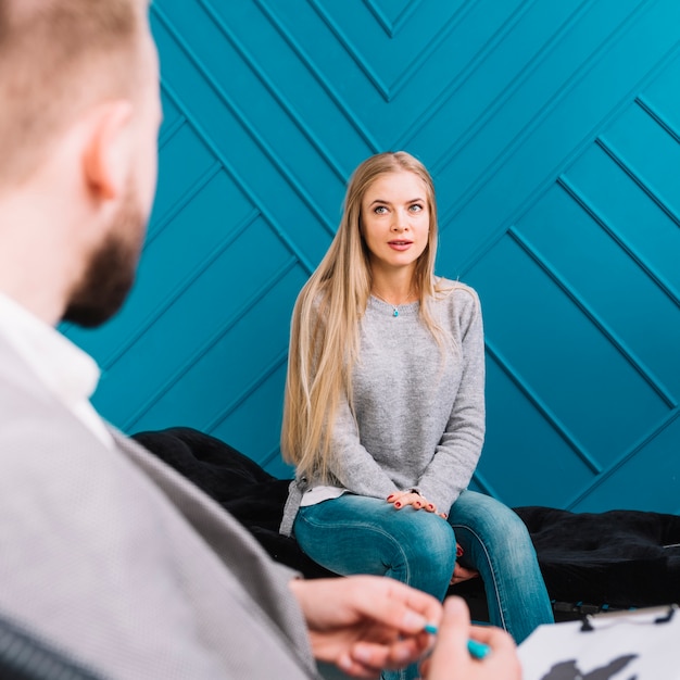 Foto psycholoog die aan haar patiënt luistert en nota's neerschrijft