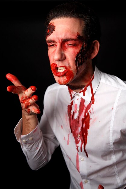 Psychopath with bloody fingers in a white shirt