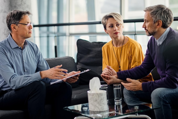 Psychotherapist having a meeting with mid adult couple at his office