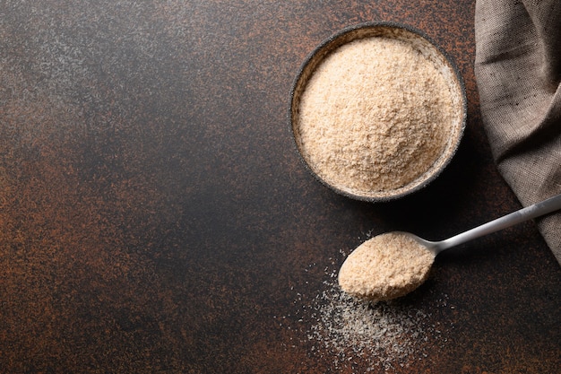 Psyllium husk in kom op donkerbruine tafel