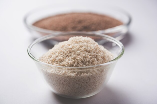 Psyllium husk 또는 isabgol은 주로 인도에서 발견되는 Plantago ovata의 씨앗에서 추출한 섬유입니다. 변덕스러운 배경 위에 그릇에 제공됩니다. 선택적 초점