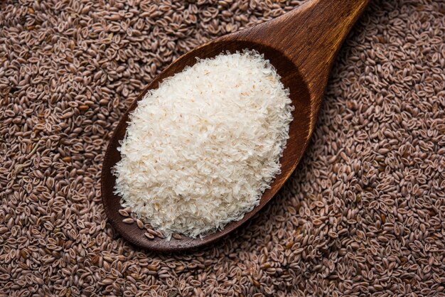 Psyllium husk 또는 isabgol은 주로 인도에서 발견되는 Plantago ovata의 씨앗에서 추출한 섬유입니다. 변덕스러운 배경 위에 그릇에 제공됩니다. 선택적 초점