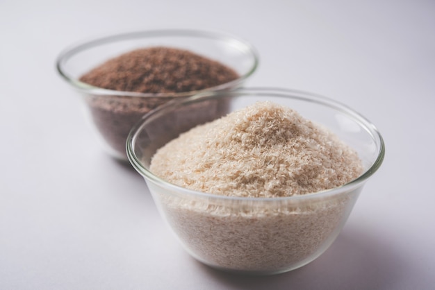 Psyllium husk 또는 isabgol은 주로 인도에서 발견되는 Plantago ovata의 씨앗에서 추출한 섬유입니다. 변덕스러운 배경 위에 그릇에 제공됩니다. 선택적 초점