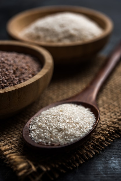 Psyllium husk of isabgol, een vezel die is afgeleid van de zaden van Plantago ovata, voornamelijk gevonden in India. Geserveerd in een kom over humeurige achtergrond. selectieve focus