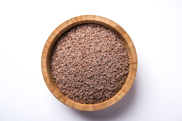 Psyllium Husk 또는 Isabgol은 주로 인도에서 발견되는 Plantago Ovata의 씨앗에서 추출한 섬유입니다. 변덕스러운 배경 위에 그릇에 제공됩니다. 선택적 초점